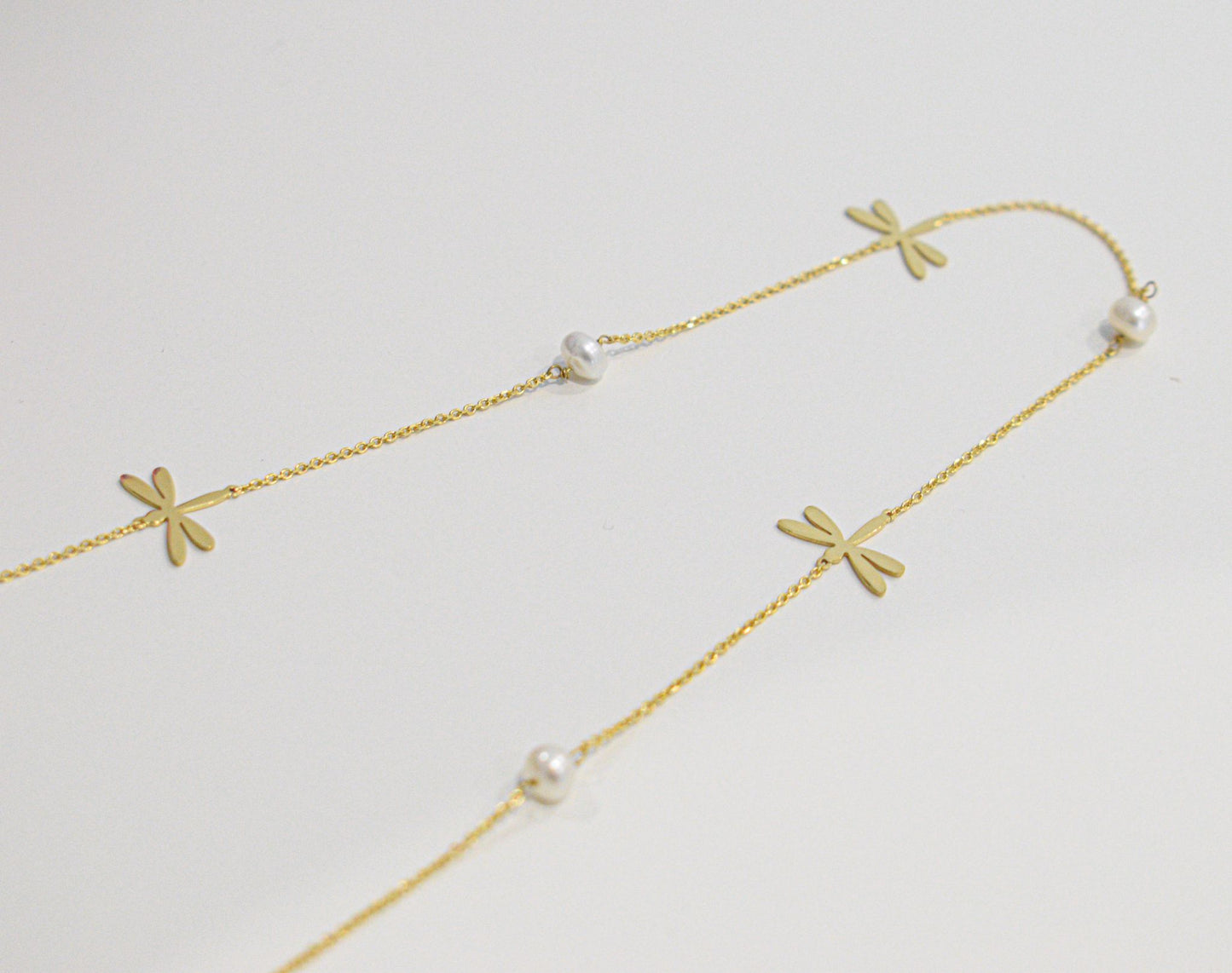 Foto panoramica della collana con perline e libellule, placcata in oro..