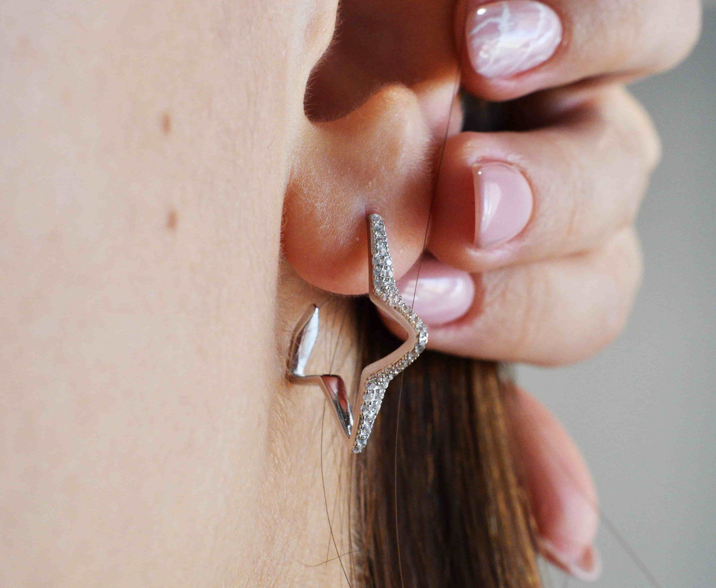 Coppia orecchini stella indossati in argento 925 e zirconi.