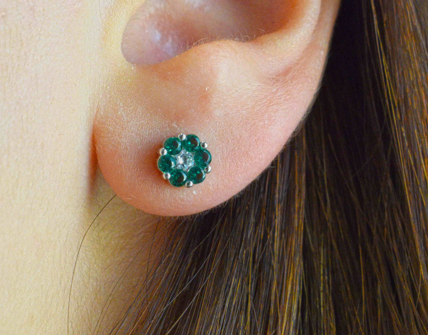 Orecchino fiorellino verde indossato.