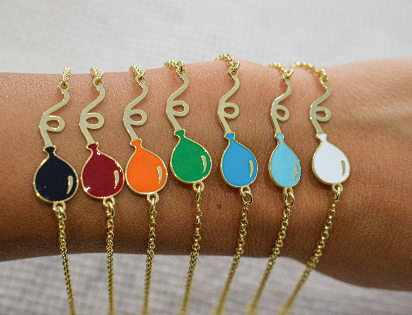 Bracciale con palloncino con colori: nero, rosso, arancione, verde, celeste, ciano e bianco