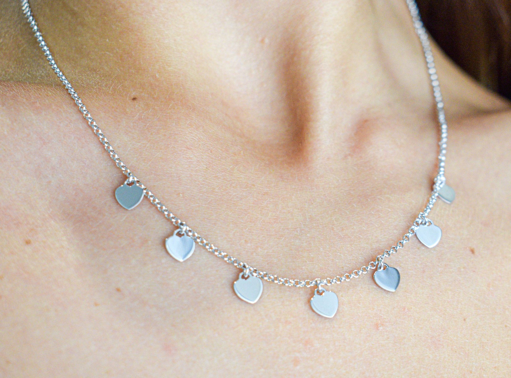 Collana con cuoricini pendenti indossata, silver.