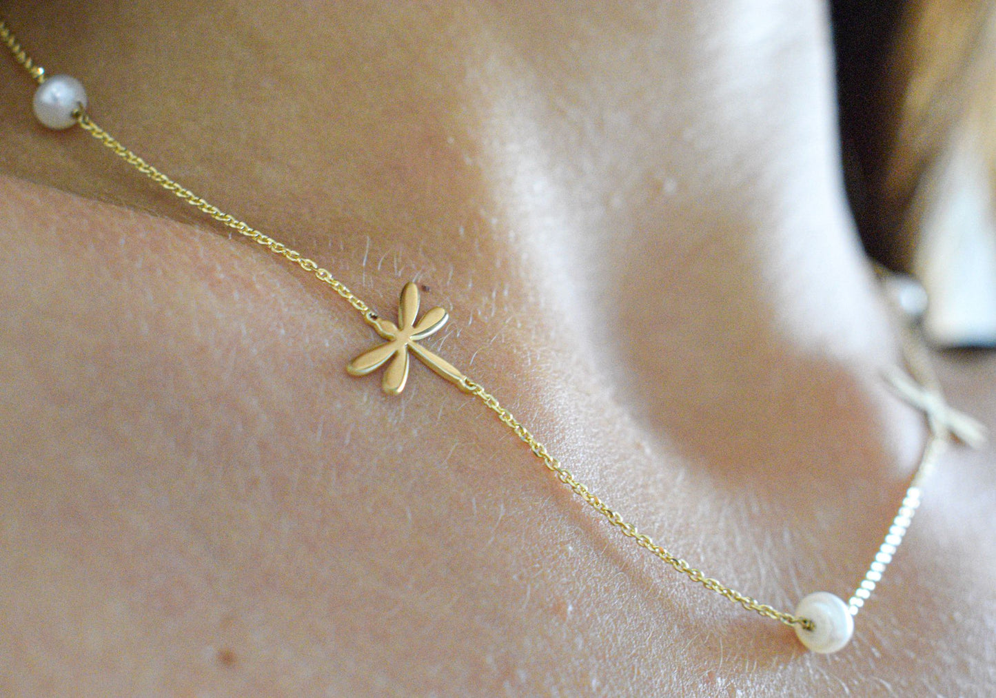 Collana con libellule e perline indossata , foto ravvicinata. 