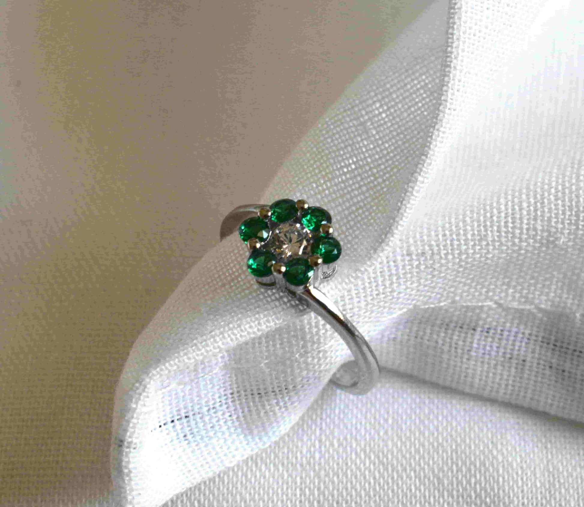 Anello Fiore Solitario in argento 925 con zircone trasparente al centro e contornato da zirconi verdi che compongono la forma di un fiore.
