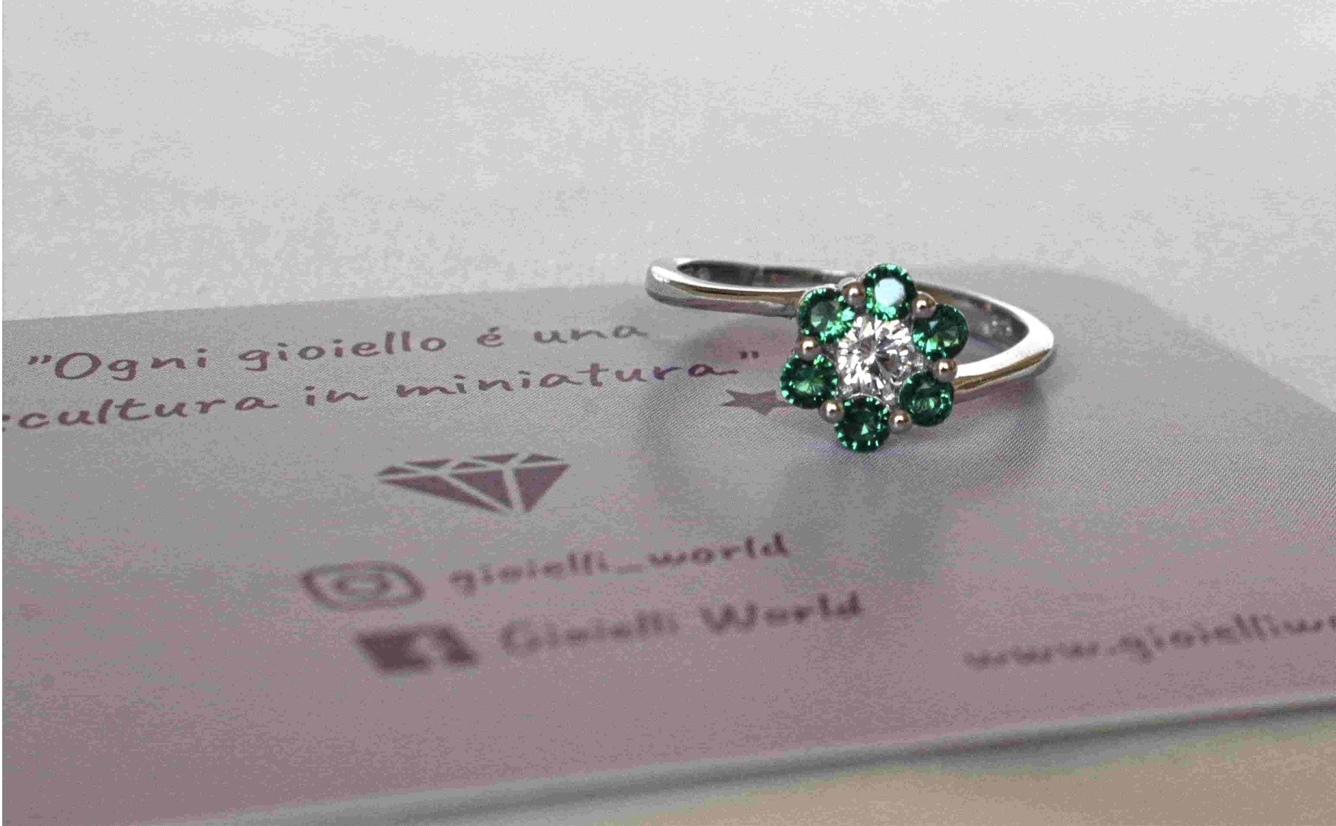 Anello Fiore Solitario in argento 925 con zircone trasparente al centro e contornato da zirconi verdi che compongono la forma di un fiore.